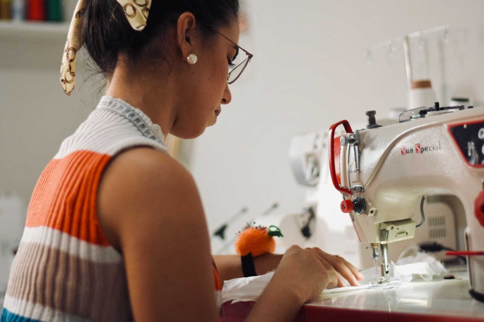 Grazyela Couto costurando em uma máquina de costura industrial