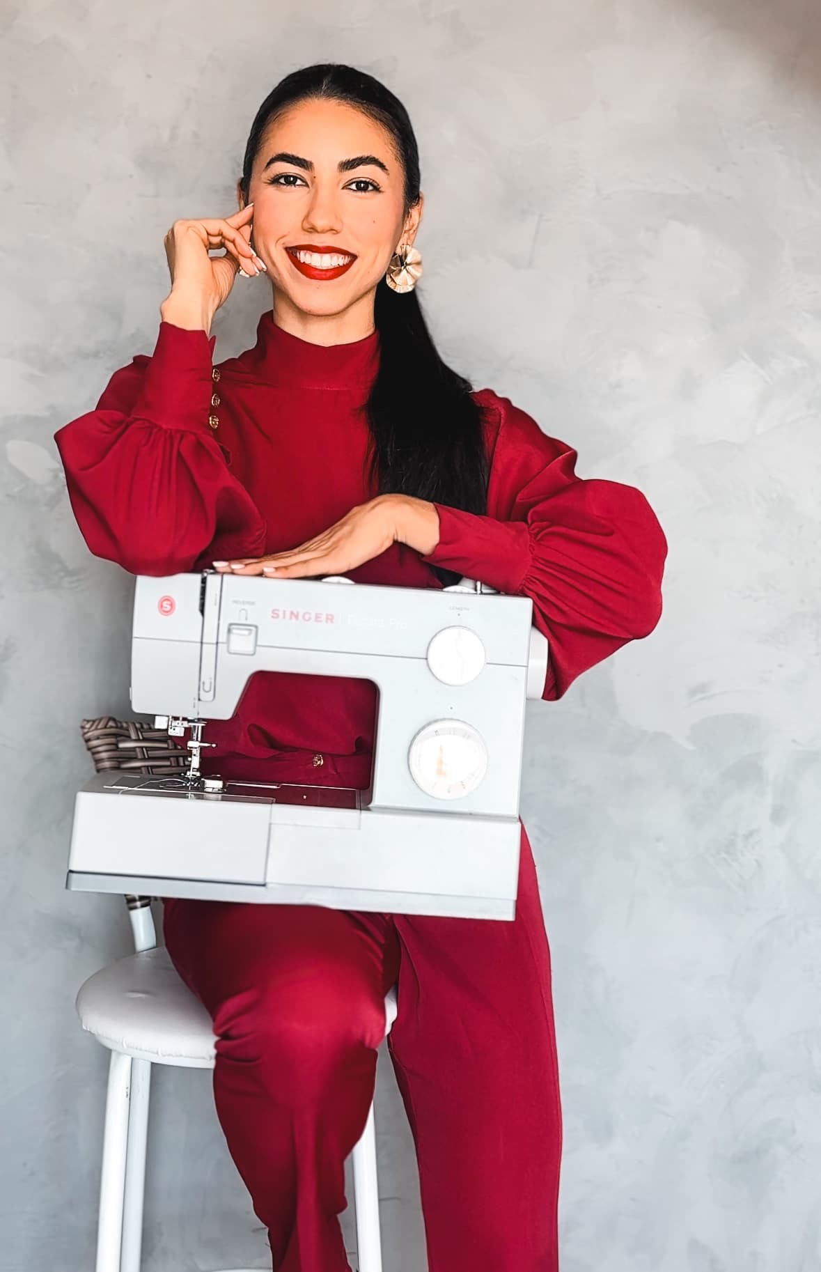 Grazyela Couto sorrindo com máquina de costura Singer